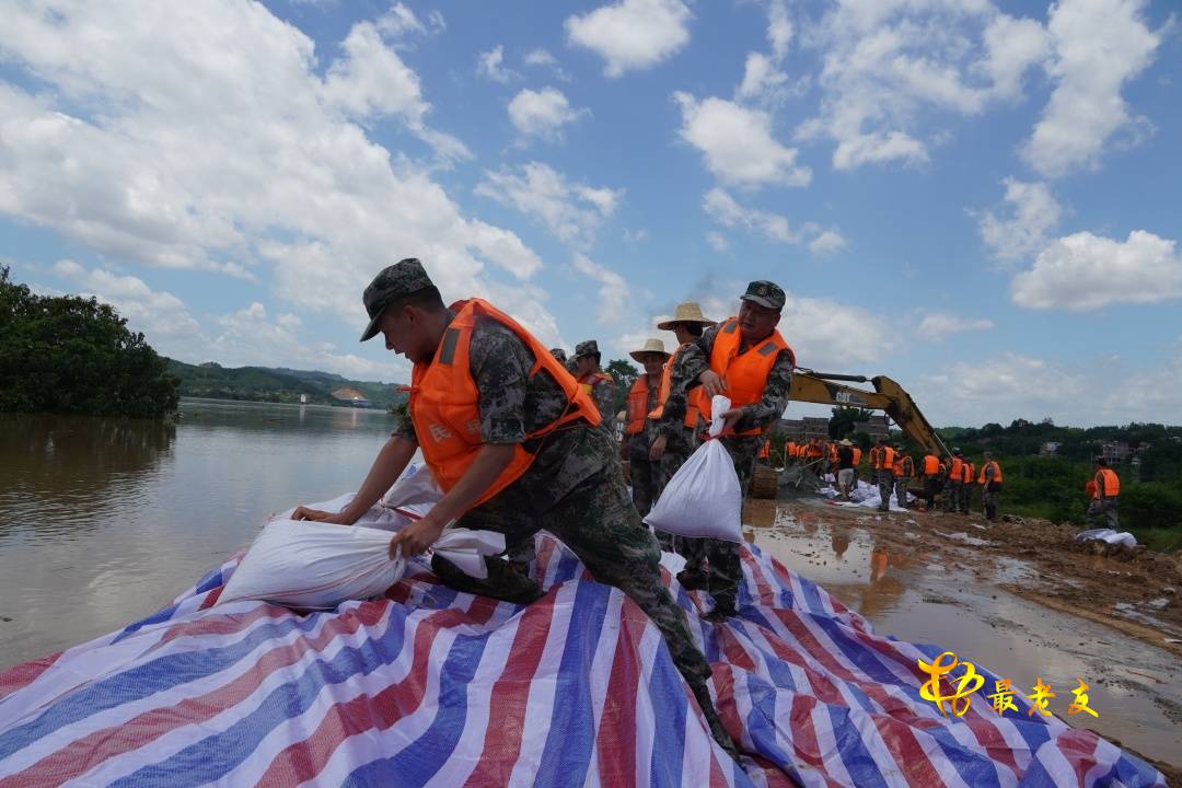 民兵们顶着烈日将一袋袋沙包垒叠在堤坝上.JPG